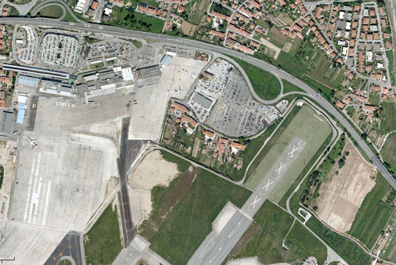 Al centro dell'immagine di Google Earth si vedono le abitazioni rimaste letteralmente circondate dal sedime dell'aeroporto di Pisa. Le caso confinano infatti a nord con un parcheggio per auto e bus, ad est con la testata della pista proncipale, a sud con la testata della pista secondaria e ad ovest col piazzale aeromobili. In alto, oltre la superstrada si può notare il quartiere cittadino di San Giusto. 